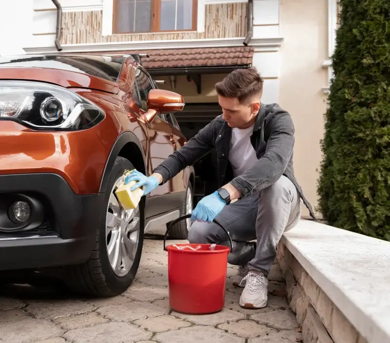 Lavage auto à domicile Auzainvilliers : professionnel intervenant sur un véhicule